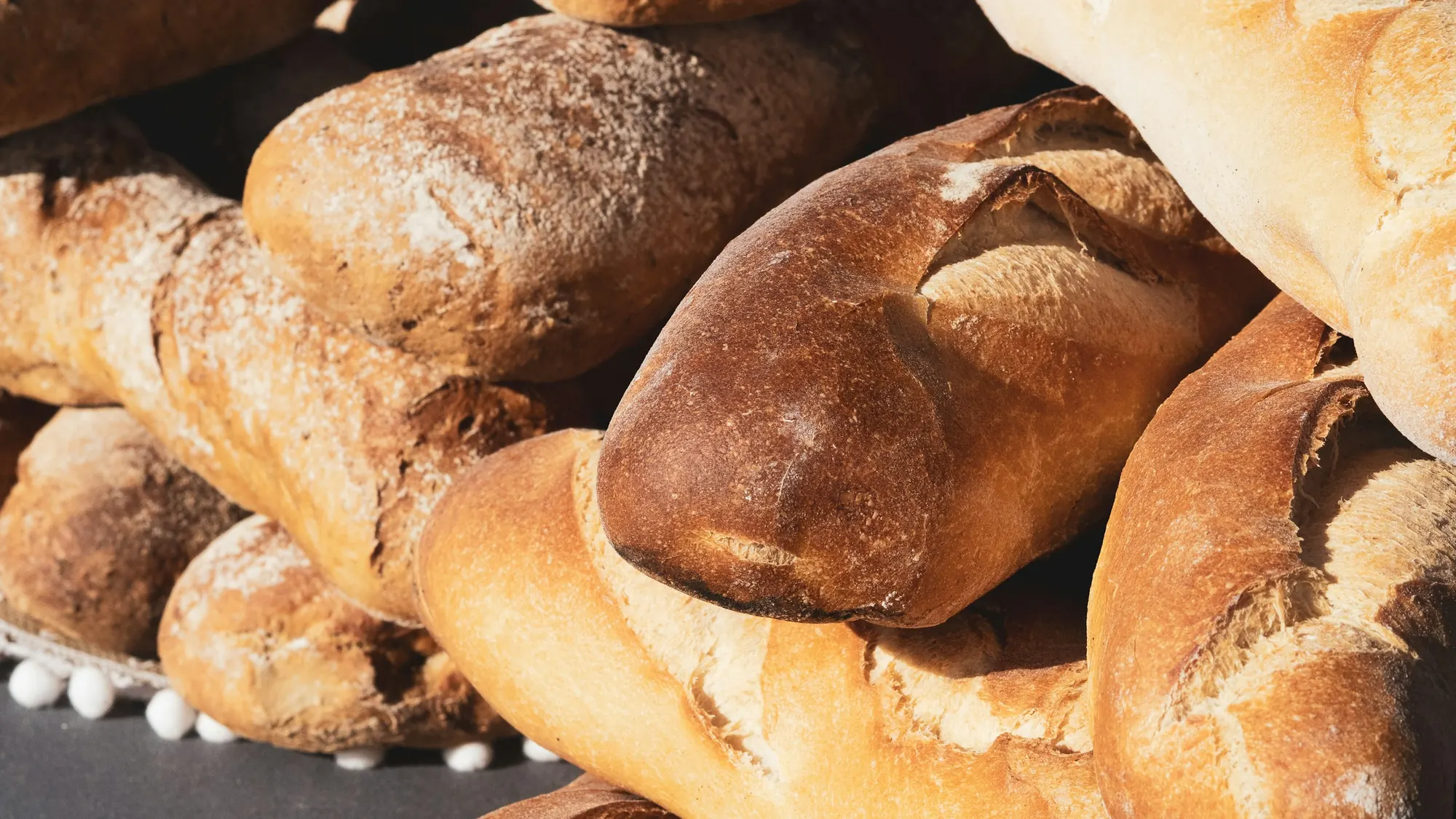 Pães, bolos, tortas e salgados da Donna Maria sobre uma mesa de madeira